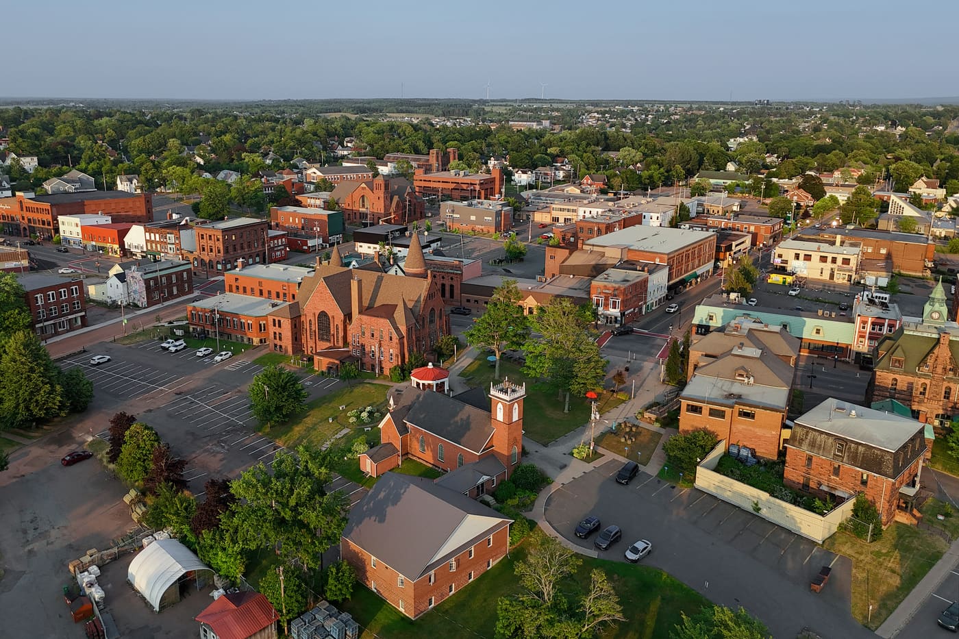 Downtown Amherst from the air at evening, brick churches and the Tantramar beyond