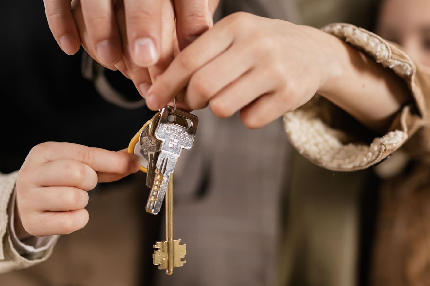 A family’s hands holding the keys to a house
